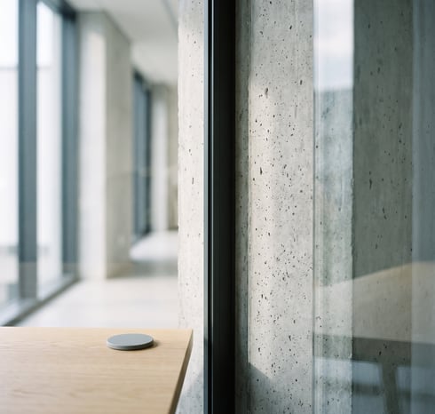 El canto de la mesa de la consulta junto al cristal, con un sensor gris encima